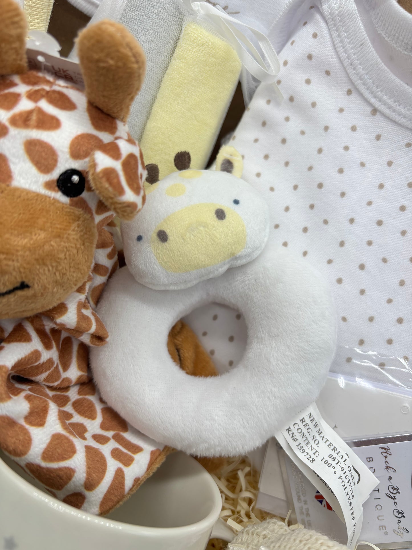 Close-up of the giraffe comforter and soft ring rattle in the gift box